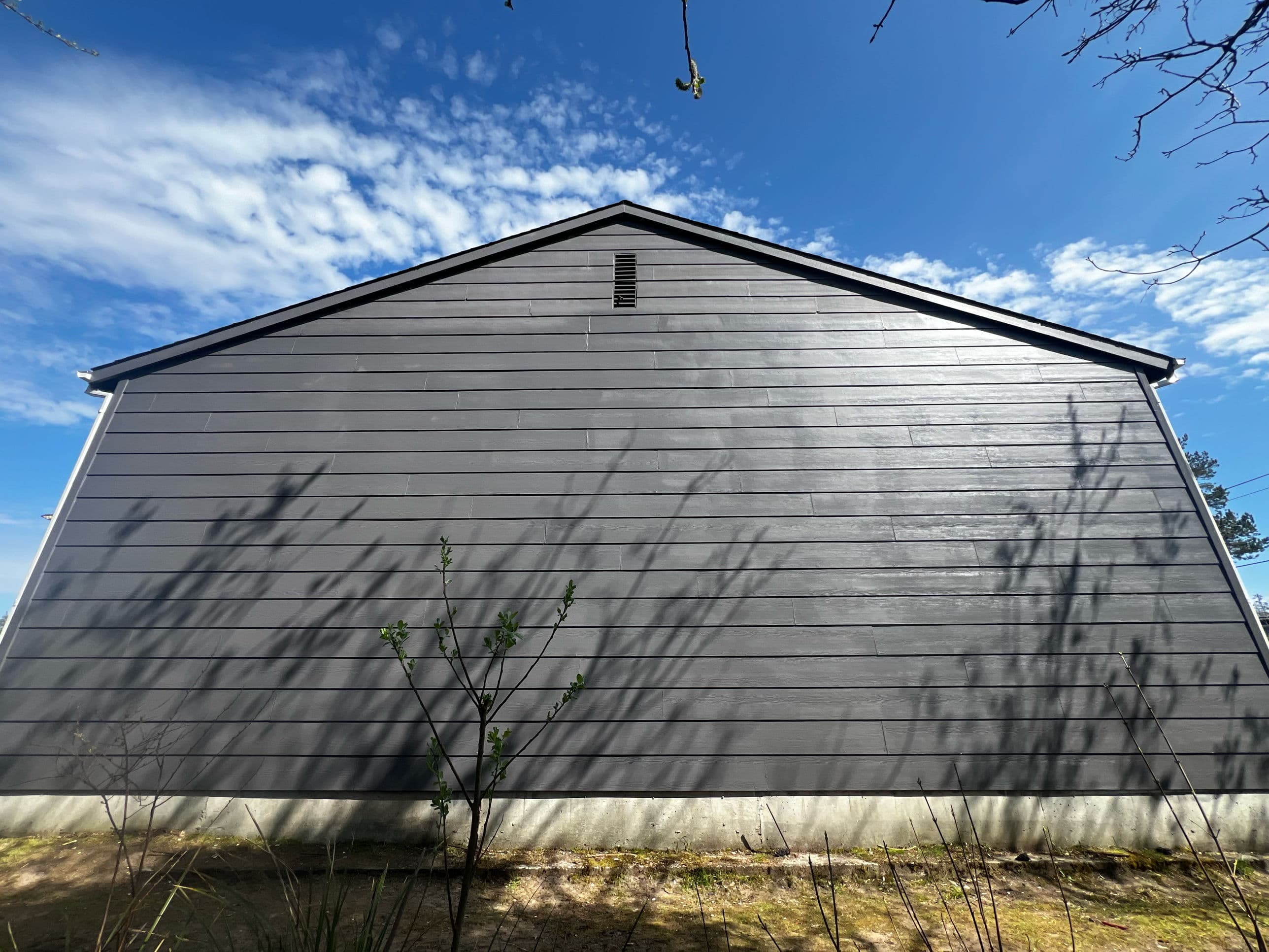 Freshly painted dark gray lap siding on a Portland home — clean lines from foundation to roofline